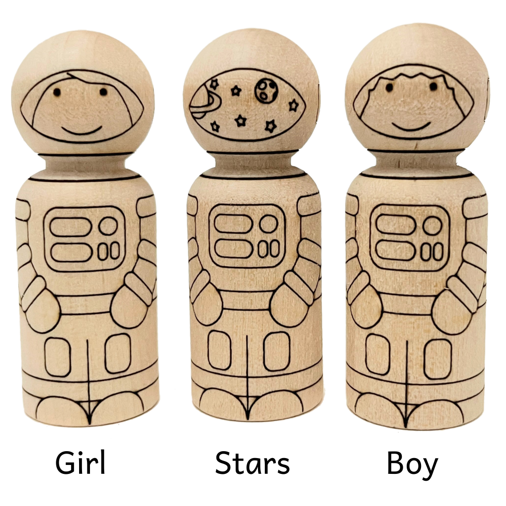 Three peg doll astronauts that are unfinished natural baltic birch. Design includes a girl, boy, and one with stars and planets on its helmet visor.